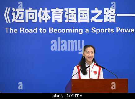 (240827) -- PEKING, 27. August 2024 (Xinhua) -- Zhang Xiaohuan, Cheftrainer des chinesischen Kunstschwimmteams und Vertreter der Goldmedaillengewinner bei den Olympischen Spielen 2024 in Paris, spricht während einer Eröffnungszeremonie in Peking, Hauptstadt Chinas, am 27. August 2024. Ein Think Tank-Bericht mit dem Titel „The Road to Being a Sports Powerhouse – the Value and Inspiration of Xi Jinping's Important Discourses on Sports“ wurde hier am Dienstag veröffentlicht. Der Bericht wurde vom Xinhua Institute, einem High-End-Think Tank der Xinhua Nachrichtenagentur, verfasst und ist in vier Abschnitte gegliedert. Sie erläutert ausführlich die Kernkonzepte von Stockfoto