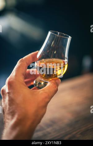 Farb-Nahaufnahme einer Hand, die ein einzelnes Glencairn Whiskyglas hält. Stockfoto