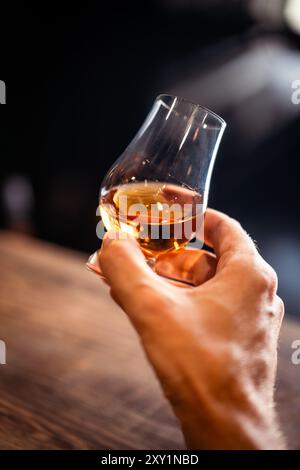 Farb-Nahaufnahme einer Hand, die ein einzelnes Glencairn Whiskyglas hält. Stockfoto