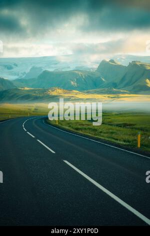 Dramatischer Blick auf die Ringstraße Route 1 in Island an einem Sommermorgen mit einem Gletscher im Hintergrund, Sturmwolken und niedrigem hängendem Nebel Stockfoto