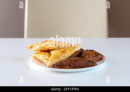 Verschiedene Gebäckstücke, die ordentlich auf einem weißen Teller in hellem Licht angeordnet sind. Stockfoto