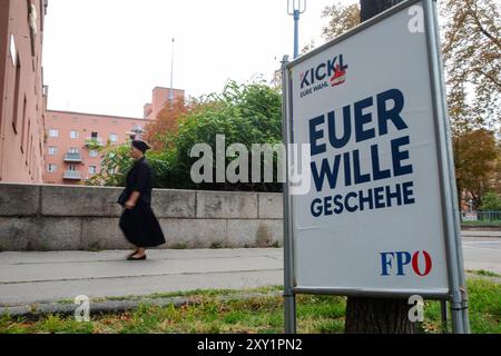 ÖSTERREICH; WIEN; 20240827; Eine Frau läuft neben einem Poster zur bevorstehenden österreichischen Nationalratswahl 2024 der Freiheitlichen Partei Österreichs (FPOe) mit dem Text: 'Ihre Wahl - Ihr wird getan', gesehen vor dem Wiener Karl-Marx Hof am 27. August 2024 in Wien. /// ÖSTERREICH; WIEN; 20240827; eine Frau geht neben einem Plakat für die kommende österreichische Nationalratswahl 2024 der Freiheitlichen Partei Österreich ( FPÖ) mit dem Text: 'Eure Wahl - eurer Wille geschehe' gesehen vor dem wiener Karl - Marx Hof in Wien am 27. August 2024. - 20240827 PD5247 Stockfoto