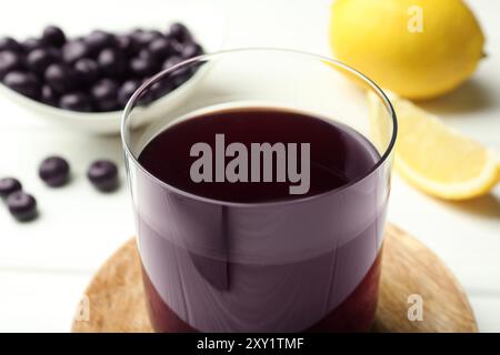 Köstlicher Acai-Saft im Glas auf weißem Tisch, Nahaufnahme Stockfoto