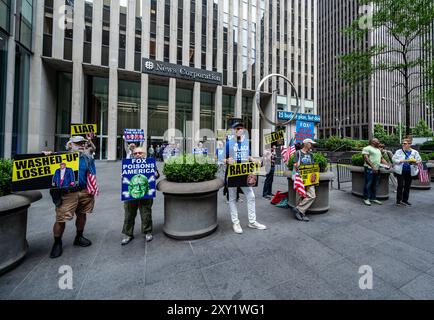 New York, NY, USA. August 2024. Die Leute protestieren auf der Straße gegen Donald Trumps Präsidentschaftskandidatur. Sie halten Schilder, die ihn beschuldigen Stockfoto