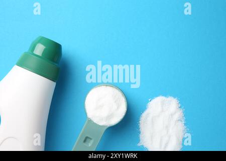 Flasche Waschmittel und Messlöffel Waschpulver auf blauem Hintergrund, flach aufgelegt. Leerzeichen für Text Stockfoto