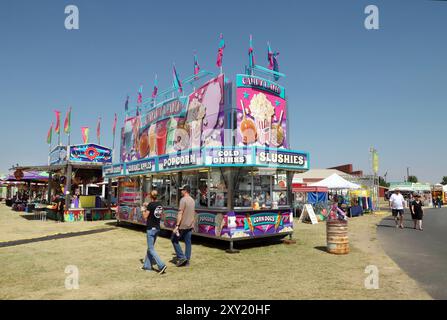 Karnevalsfahrten und Lebensmittelhändler sind auf dem Gelände und auf halbem Weg der Deschutes County Fair 2024 in Redmond, Oregon. Stockfoto
