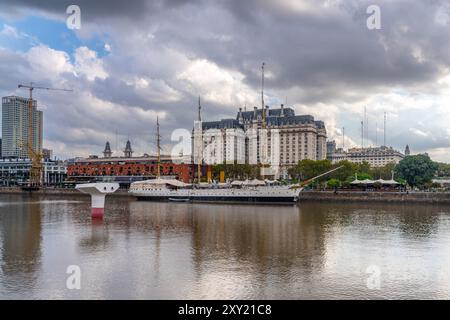 La Puente de la Mujer oder die Frauenbrücke über Dock 3 in Puerto Madero, Buenos Aires, Argentinien. Dahinter befindet sich das Schiff der ARA Presidente Sarmiento und Th Stockfoto