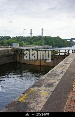 Irlam, Manchester, Großbritannien, 26. August 2024: ein altes Schleusentor mit bewachsener Vegetation unter bewölktem Himmel. Stockfoto