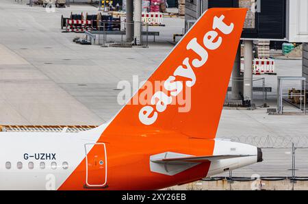 München, Deutschland, 7. April 2024: Heckflosse eines Airbus A320-251N (Airbus A320neo) mit dem EasyJet-Logo auf der Start- und Landebahn am Flughafen München. Registrierung G- Stockfoto