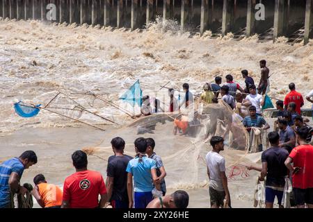 Feni, Chittagong, Bangladesch. August 2024. 27. August 2024, Feni, Chittagong, Bangladesch: Fischer und gewöhnliche Menschen fischen mit handgefertigten Netzen am Ufer des Feni River, wobei sie den starken Fluss von Hochwasser entlang des Muhuri-Projekts in Sonagazi Upazila, Bezirk Feni, Division Chittagong, Bangladesch ignorieren. (Kreditbild: © Muhammad Amdad Hossain/ZUMA Press Wire) NUR REDAKTIONELLE VERWENDUNG! Nicht für kommerzielle ZWECKE! Stockfoto