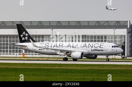 München, 8. April 2024: Ein Lufthansa Airbus A320-214 fährt mit dem Taxi zur Start- und Landebahn am Flughafen München. Das Flugzeug trägt die StarAlliance-Lackierung. Registrati Stockfoto