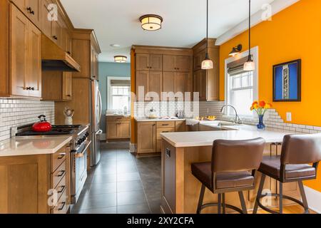 Renovierte Küche in einem älteren Haus mit Holzschränken und hellen orangefarbenen Wänden Stockfoto