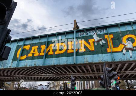 Die legendäre Eisenbahnbrücke Camden Lock aus Metall, die den Regent's Canal in Camden Town, London, überquert. Die Brücke ist mit einem Schild verziert. Stockfoto