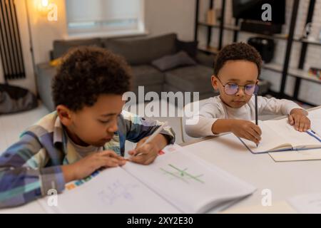 afroamerikanische Jungs machen Unterricht und schreiben etwas in ein Notizbuch Stockfoto