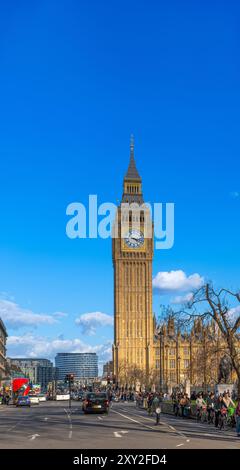 Menschen und Touristen gehen entlang einer Londoner Straße mit Ampeln und Verkehrsschildern und dem Big Ben Clock Tower im Hintergrund mit einem sonnigen blau Stockfoto