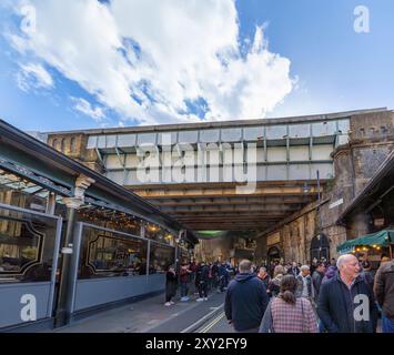 Eingang unter der Eisenbahnbrücke zum modernen Borough Market, mit dem alten Lee Brothers Potato Merchants Schild über dem Eingang zum Marktplatz Stockfoto