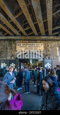 Eingang unter der Eisenbahnbrücke zum modernen Borough Market, mit dem alten Lee Brothers Potato Merchants Schild über dem Eingang zum Marktplatz Stockfoto