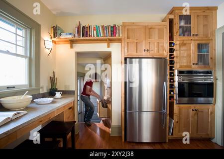 Frau in der Küche, die Gegenstände in die Recyclingschublade legt Stockfoto