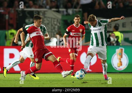 27. August 2024, Nordrhein-Westfalen, Münster: Fußball: DFB-Cup, Preußen Münster - VfB Stuttgart, 1. Runde im Stadion an der Hammer Straße. Münsters Joel Grodowski (r) kämpft um den Ball mit Stuttgarter Angelo Stiller (l). Foto: Friso Gentsch/dpa - WICHTIGER HINWEIS: Gemäß den Vorschriften der DFL Deutschen Fußball-Liga und des DFB Deutschen Fußball-Bundes ist es verboten, im Stadion und/oder im Spiel aufgenommene Fotografien in Form von sequenziellen Bildern und/oder videoähnlichen Fotoserien zu verwenden oder zu verwenden. Stockfoto