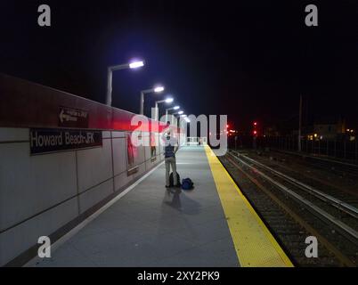 Warten auf einen U-Bahn-Zug auf einem Bahnsteig an der JFK Howard Beach Station in Queens, NYC Stockfoto