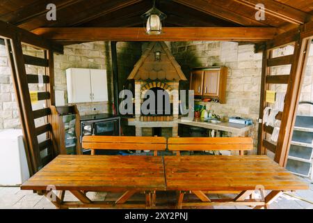 Hölzerner Pavillon im Innenhof mit Tischen und Bänken in der Nähe des Herds Stockfoto