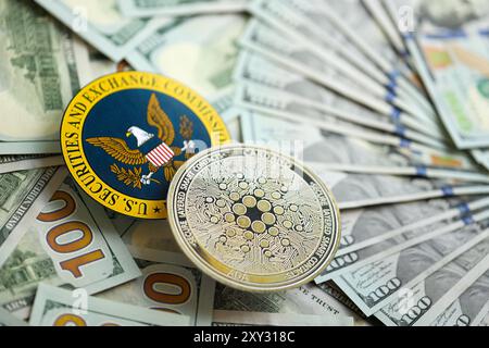 KIEW, UKRAINE - 17. AUGUST 2024 Cardano ADA Münze und US Securities and Exchange Commission unterzeichnen auf Geldhintergrund Nahaufnahme Stockfoto