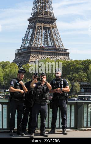 Im Zuge der Paralympischen Spiele 2024 in Paris wurde eine große Zahl von Polizisten auf den Straßen von Paris eingesetzt. Einige Polizisten nehmen sich einen Moment Zeit, um ein Selfie vor dem Eiffelturm zu schnappen, das mit den Olympischen Ringen vor der Eröffnung der Paralympischen Spiele 2024 in Paris glänzt. Dies ist das erste Mal, dass Frankreich die Paralympics ausrichtet. Veranstaltungen finden an berühmten Orten wie dem Eiffelturm, den Champs-Elysées und der seine statt und verbinden Sport mit der Schönheit von Paris. Im Laufe von elf Tagen wurden 4.400 Elite-Athleten aus der ganzen Welt Stockfoto