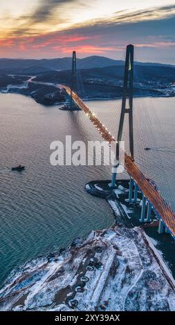 Winteransicht des Sonnenuntergangs über der berühmten Kabelbrücke von Wladiwostok zur Russki Insel, im Fernen Osten Russlands Stockfoto