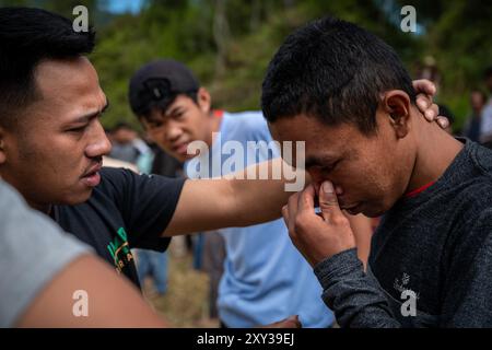 Toraja Utara, Süd-Sulawesi, Indonesien. August 2024. Ein Bewohner bekommt eine Wunde im Gesicht, nachdem er sich gegenseitig getreten hat, während er in Panggala, North Toraja Regency, Süd-sulawesi, Indonesien, die Tradition der Sisemba (sich gegenseitig treten) innehat. Am Donnerstag, 27. August 2024. Die Tradition ist ein Ausdruck der Dankbarkeit für die Kulturen und basiert auf der Überzeugung, dass die Veranstaltung sie für die bevorstehenden Arbeiten begeistern wird, um die nächsten reichlichen Ernten zu erhalten. Ohne Sisemba zu spielen, glauben die Leute von Tana Toraja, dass es zu Ernteversagen kommen wird. Die Tradition soll Verwandtschaftswerte aufrechterhalten Stockfoto