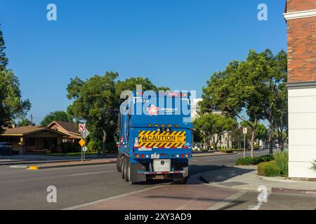 Anaheim, CA, USA - 26. Juli 2024: Das Heck eines von Republic Services betriebenen Müllwagens mit einem Warnschild auf einer Straße in Anaheim, Kalifornien. Stockfoto