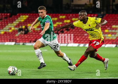 Adam Randell aus Plymouth Argyle wird von Edo Kayembe aus Watford während des Carabao Cup Matches Watford gegen Plymouth Argyle in der Vicarage Road, Watford, Großbritannien, 27. August 2024 unter Druck gesetzt (Foto: Izzy Poles/News Images) Stockfoto