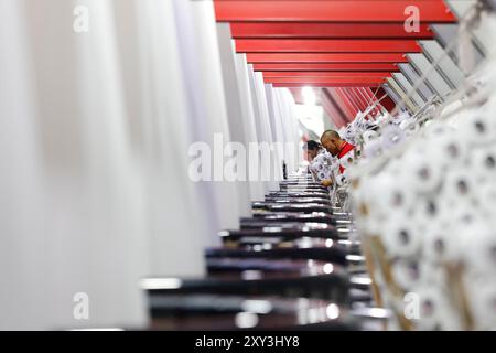 SUQIAN, CHINA - 27. AUGUST 2024 - Ein Arbeiter stellt in einer Werkstatt in Suqian, Jiangs, Kunststoffgewebe für den Export in südostasiatische Länder her Stockfoto