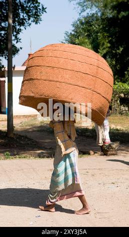 Ein Odia-Mann, der einen riesigen Korb auf dem Kopf trägt. Foto auf einem ländlichen Wochenmarkt im Süden von Odisha, Indien. Stockfoto