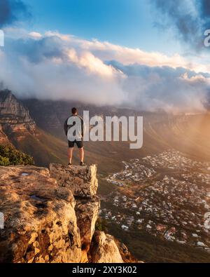 Junger Mann, der auf dem Felsen steht. Erfolg, Konzept des erreichten Ziels, Foto in Kapstadt, Südafrika Stockfoto