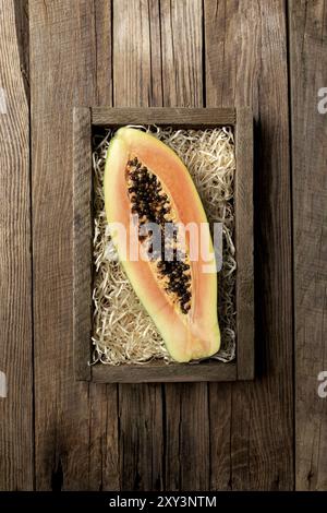 Frische tropische Papaya-Früchte in einem Holzlieferkarton Ein hölzerner Hintergrund flach Lay Draufsicht mit Kopierraum Für einige Werbetexte Stockfoto