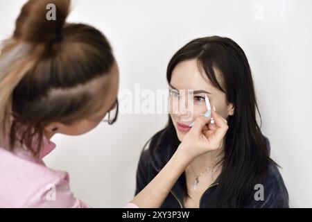 Maskenbildner malt Augenbrauen für ein junges Mädchen Stockfoto