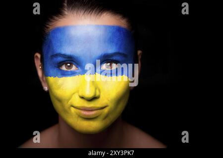 Porträt einer Frau mit der Flagge der Ukraine im Gesicht Stockfoto