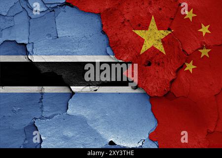 Flaggen von Botswana und China auf gerissene Wand gemalt Stockfoto