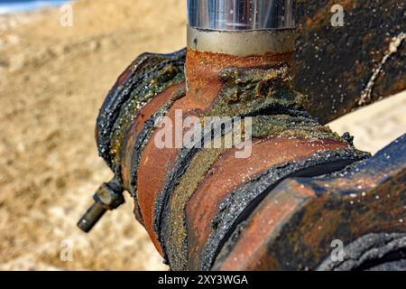 Detail der rostigen und schmutziges Öl Zahnrad von einem Bulldozer am Strand Stockfoto