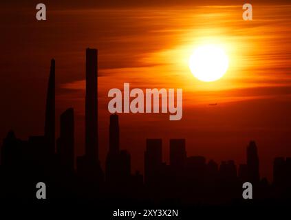 Flushing Meadow, United, Sagte. August 2024. Die Sonne untergeht hinter der Skyline von Manhattan von der Spitze des Arthur Ashe Stadions in der ersten Runde der US Open Tennis Championships 2024 im USTA Billie Jean King National Tennis Center am Dienstag, den 27. August 2024 in New York City. Foto: John Angelillo/UPI Credit: UPI/Alamy Live News Stockfoto