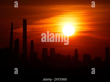 Flushing Meadow, United, Sagte. August 2024. Die Sonne untergeht hinter der Skyline von Manhattan von der Spitze des Arthur Ashe Stadions in der ersten Runde der US Open Tennis Championships 2024 im USTA Billie Jean King National Tennis Center am Dienstag, den 27. August 2024 in New York City. Foto: John Angelillo/UPI Credit: UPI/Alamy Live News Stockfoto