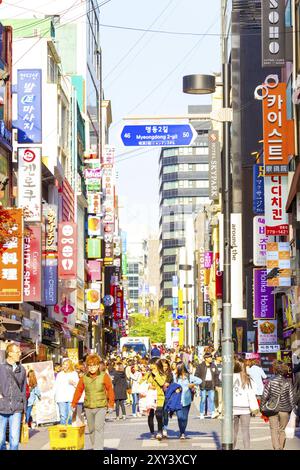 Seoul, Südkorea, 17. April 2015: Touristen gehen die geschäftige Myeongdong Fußgängerzone entlang, umgeben von kommerziellen Geschäften, Schildern Stockfoto