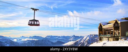 Winter Berg Reise Urlaub Hintergrund. Seilbahn Straßenbahn Kabine, Schnee, hohe Gipfel und blauen bewölkten Himmel Stockfoto