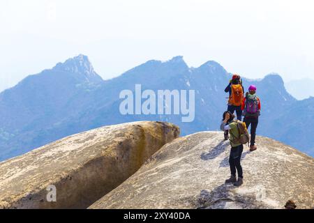 Seoul, Südkorea, 23. April 2015: Drei Frauen in voller farbenfroher Wanderausrüstung, die die Berglandschaft vom Gipfel des Bukhansan, Baegundae, betrachten Stockfoto