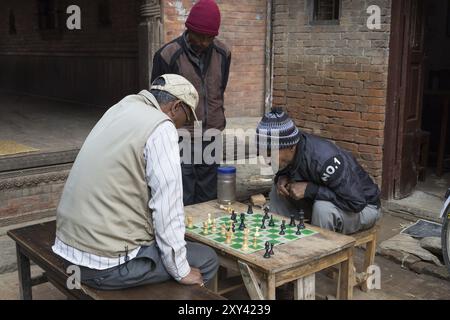 Bhaktapur, Nepal, 5. Dezember 2014: Ältere Männer spielen Schach auf den Straßen, Asien Stockfoto