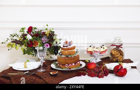 Desserttisch gewartet für eine Hochzeit. Kuchen, Muffins, süße und Blumen Stockfoto