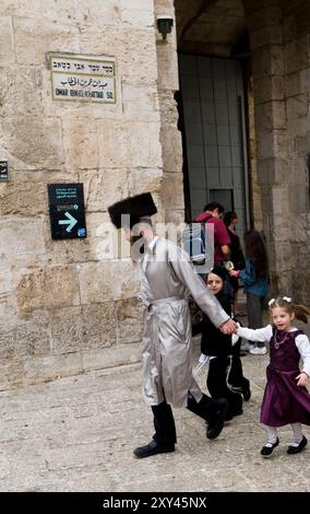 Ein chassidischer Mann, der durch den Omar Ibn El-Khattab Square läuft. In der Nähe des Jaffa-Tores in der Altstadt von Jerusalem. Stockfoto