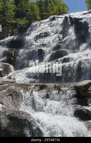 Ein majestätischer Wasserfall fließt in mehreren Kaskaden über Felsen, umgeben von Bäumen bei sonnigem Wetter, Cascada del Caozo, Garganta de Bonal de los Llanos, P Stockfoto