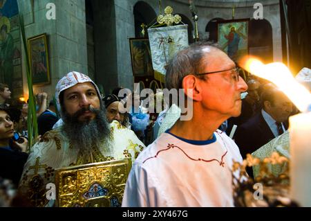 Koptische Priester in der Palmensonntagsprozession um die Ädikel in der Grabeskirche in der Altstadt von Jerusalem. Stockfoto