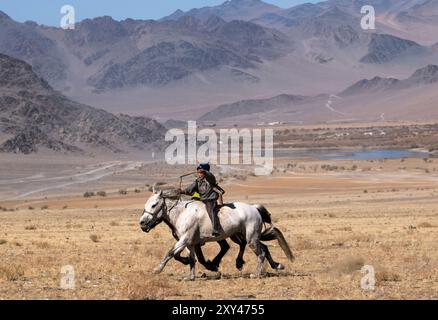 Kasachische Adlerjäger treten beim Tiyn Teru - Münzabholer-Pferderennen in der Region Altai in der Westmongolei an. Stockfoto